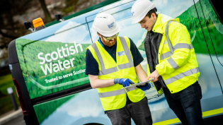 Two graduates pictured with Scottish Water van behind