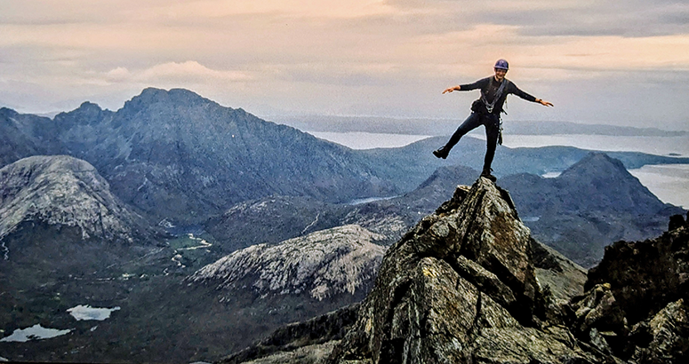  Mountaineer Tom Millar founder Munro Challenge WaterAid  balancing on one leg at the summit of Sgurr nan Gillean