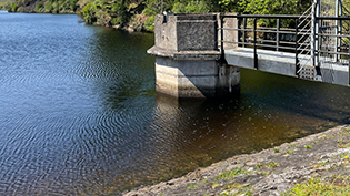 Water Efficiency reservoir edge  with water tower showing low water line with water tower