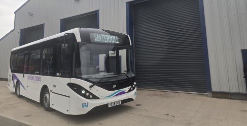 Shuttle Bus service put on for customers during Castle Rd Closure A bus with "Watermill" as its destination, parked outside a modern industrial building.