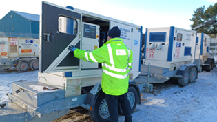 Man in hi vis jacket in front of mobile generator