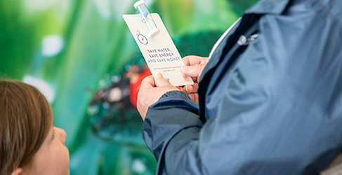 Unknown member of the public with a young child holding a shower timer