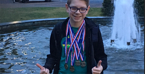 Learn to Swim instructor Nathan McKechnie with his medals as a young child