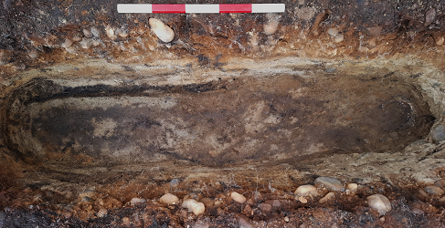 Final excavation image of grave showing surviving cranial elements to right and stain of body in the sandy matrix