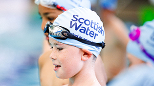 Young boy with Learn to Swim swimming cap on