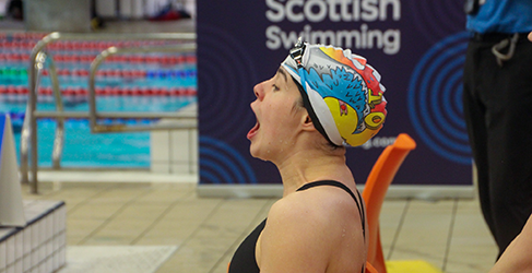 Commonwealth Games finalist Holly McGill models winning  cap design at pool